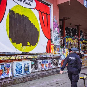 Eine Polizistin vor dem übermalten Plakat an der Roten Flora.