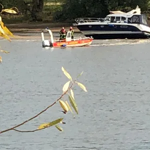 Feuerwehrmänner in einem Kleinboot bei der verunglückten Yacht.