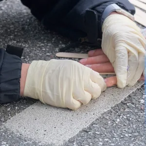 Spezialeinsatzkräfte der Polizei lösen Hand von Asphalt.