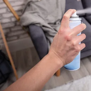 Ein Mann versprüht ein Raumspray (Symbolbild).