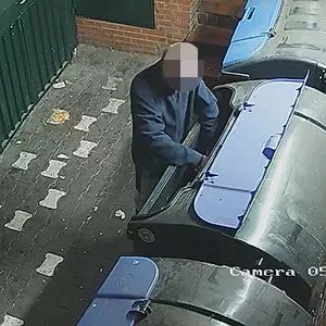 Der Mann legt in der Altpapiertonne ein Feuer.