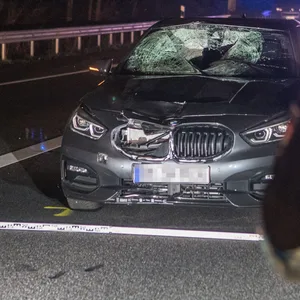 Ein Polizist steht vor dem Auto, mit dem der Mann angefahren wurde.