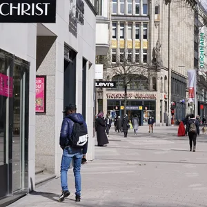 Passanten gehen durch die Einkaufsstraße Spitalerstraße in der Innenstadt. Händler:innen leiden unter dem zunehmenden Online-Geschäft. EIne App soll das ändern.