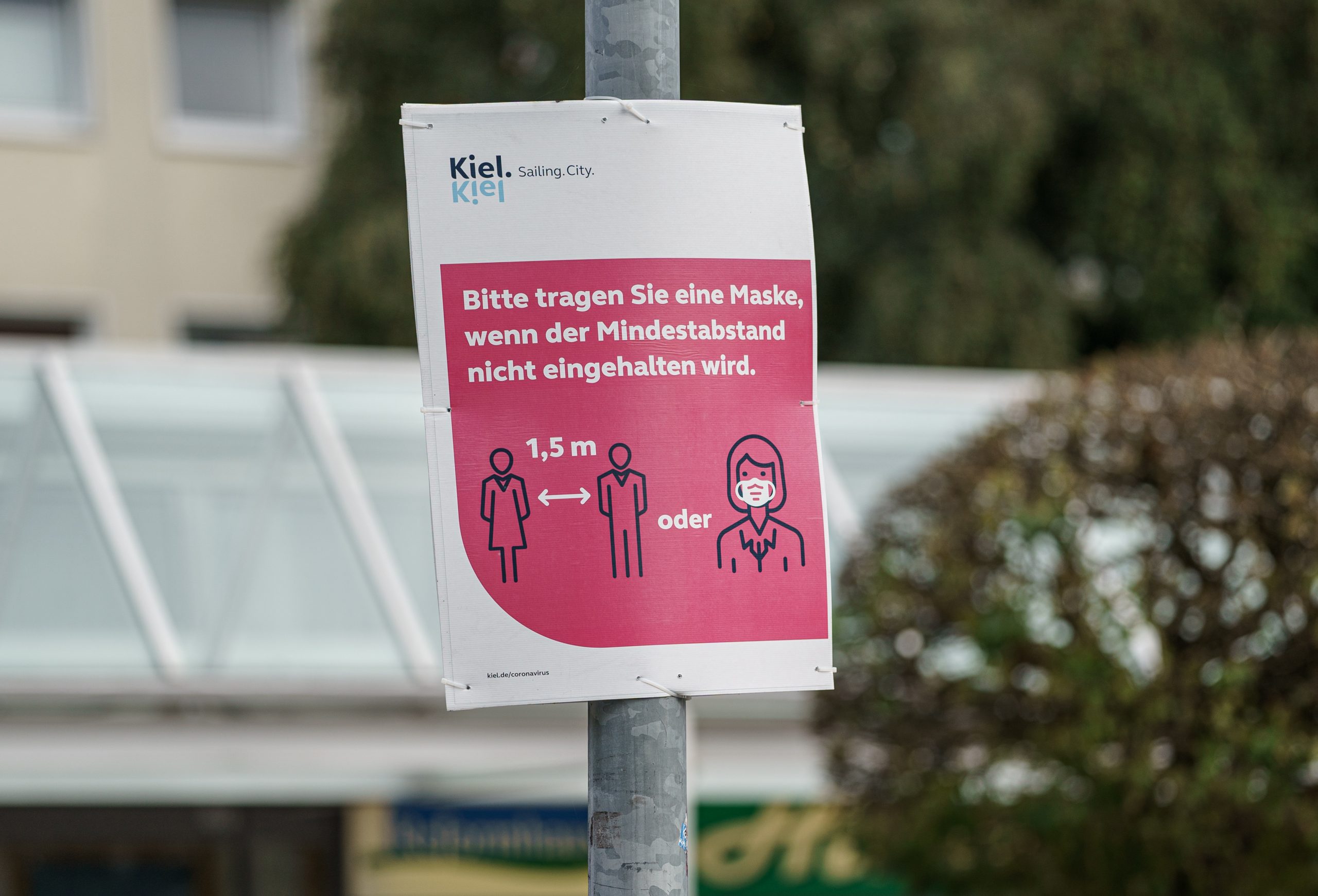 Auf einem Schild in der Kieler Innenstadt wird um das Tragen einer Maske gebeten.