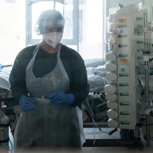 Eine Mitarbeiterin der Pflege steht in einem Patientenzimmer der Corona-Intensivstation des Universitätsklinikums Essen.