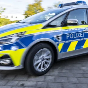 Ein Polizeiwagen fährt mit eingeschaltetem Blaulicht zu einem Einsatz