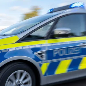 Ein Polizeiwagen fährt mit eingeschaltetem Blaulicht.