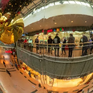Die Innenansicht des Einkaufszentrum Strelapark mit eine Schlange von Impflingen spiegelt sich in einer Weihnachtskugel