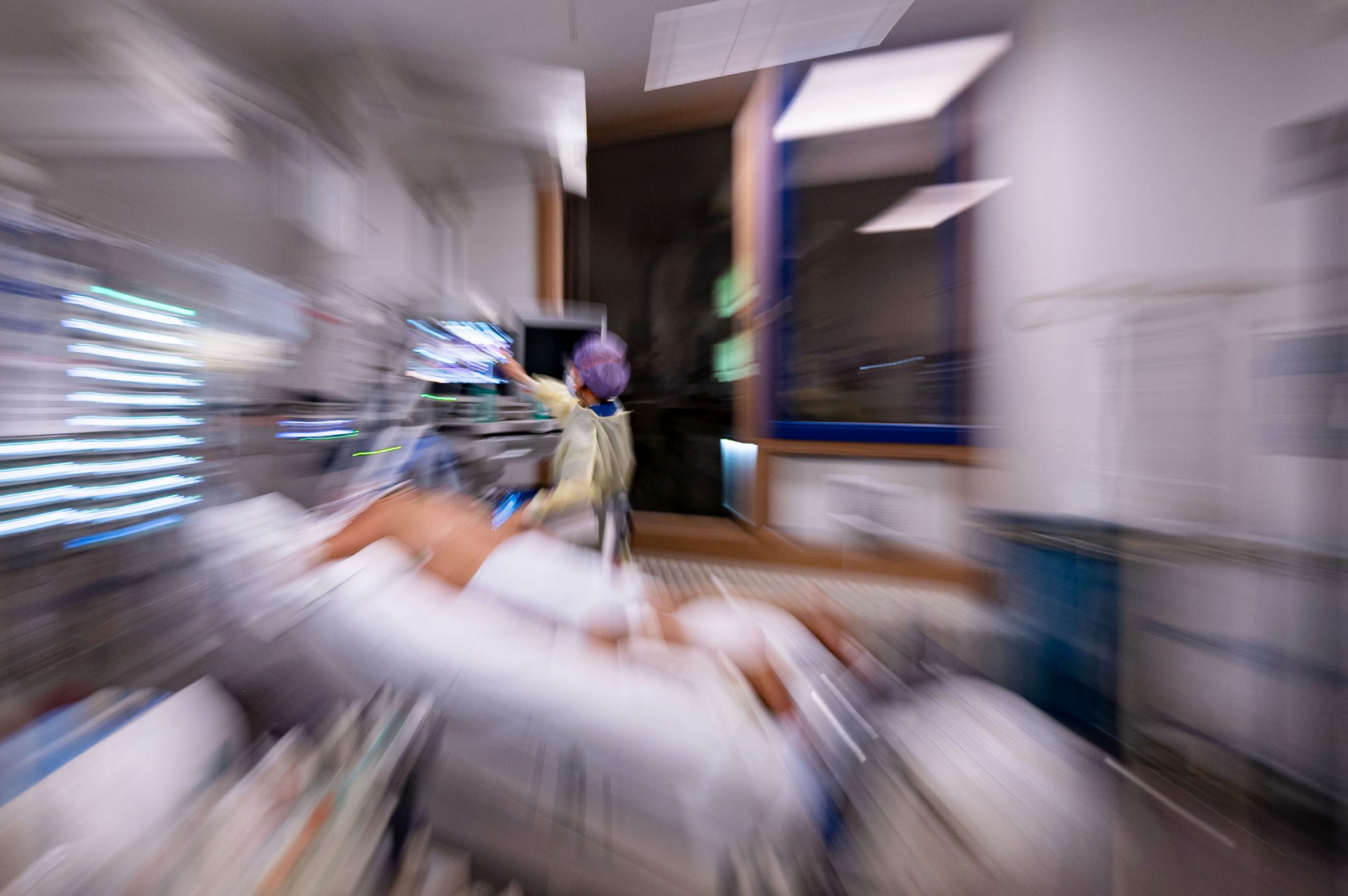 Eine Krankenpflegerin versorgt in einem Patientenzimmer eines abgetrennten Bereichs für Covid-19 Patienten einer Intensivstation