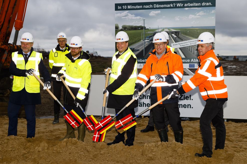 Mikkel Hemmingsen (l-r), Vorstand der Firma Sund und Baelt, Jens Ole Kaslund, Technischer Direktor der Firma Femern a-s, Benny Engelbrecht, Verkehrsminister von Dänemark, Enak Ferlemann (CDU), Parlamentarischer Staatssekretär im Bundesverkehrsministerium, Bernd Buchholz (FDP, Verkehrsminister von Schleswig-Holstein und Stefan Krenz von der Autobahn AG, stehen beim symbolischen, ersten Spatenstich für den Bau des Fehmarnbelt-Tunnels auf der Insel Fehmarn zusammen.