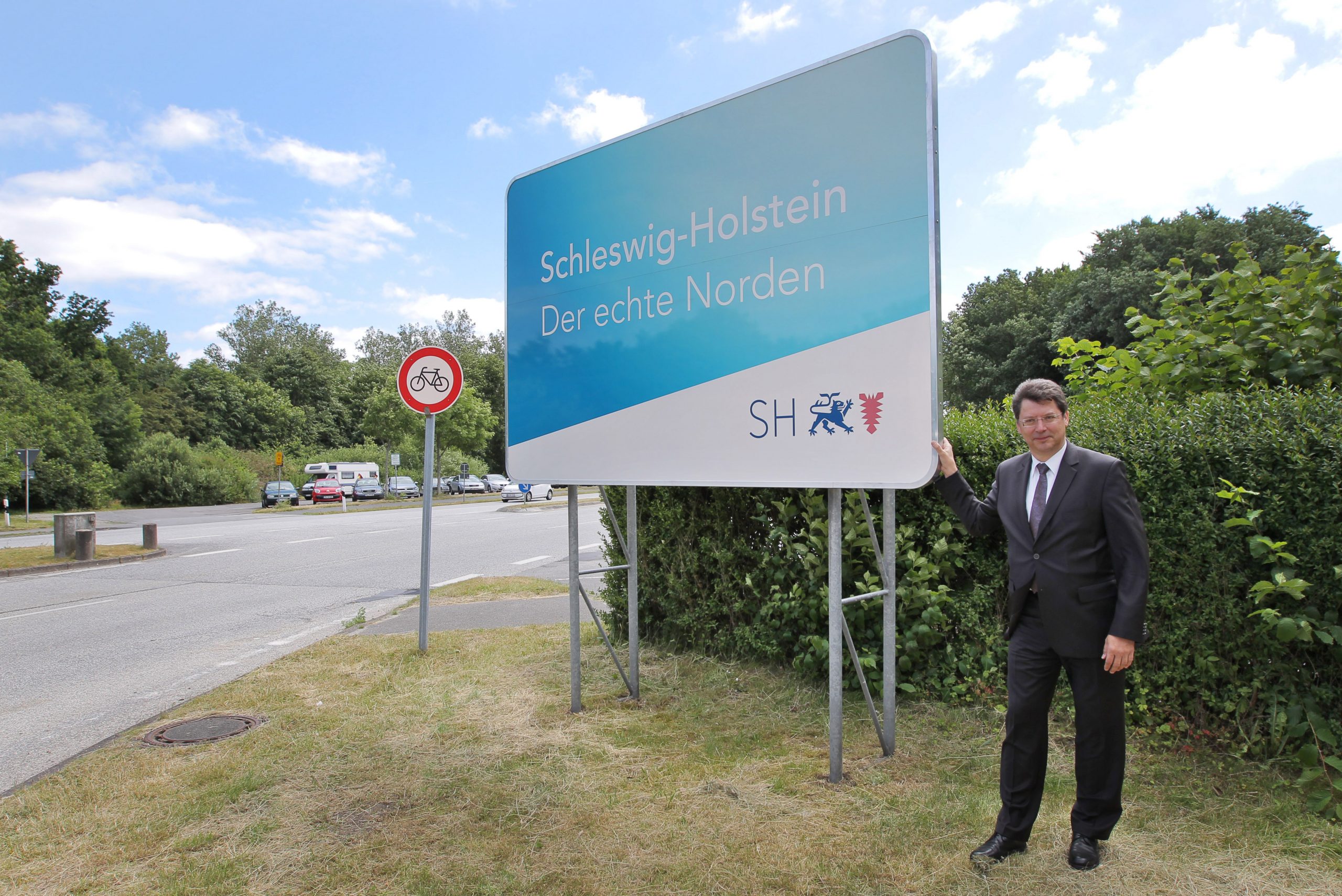 Verkehrsminister Reinhard Meyer (SPD) stellt am 23.06.2014 in Harrislee (Schleswig-Holstein) bei Flensburg das neue Schild mit dem offiziellen Slogan des Landes Schleswig-Holstein Der echte Norden» vor.