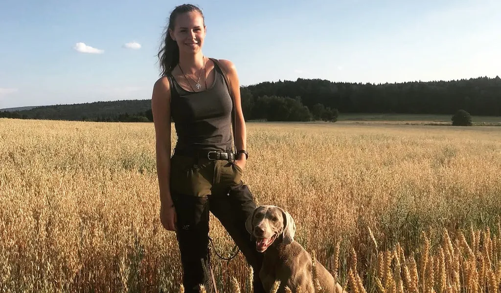 Fee Brauwers steht mit ihrem Hund Cajou in einem Weizenfeld