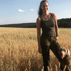 Fee Brauwers steht mit ihrem Hund Cajou in einem Weizenfeld