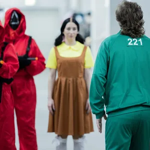 Mitarbeiter des Kostümhändlers Deiters posieren in Kostümen aus der Serie "Squid Game" des Streaming-Anbieters Netflix.