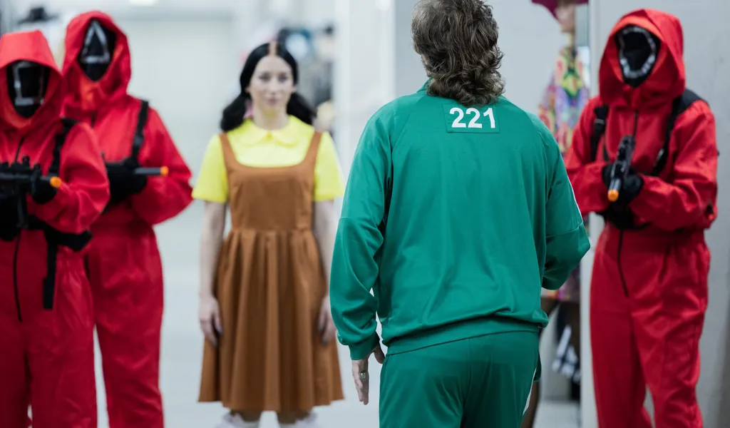 Mitarbeiter des Kostümhändlers Deiters posieren in Kostümen aus der Serie "Squid Game" des Streaming-Anbieters Netflix.