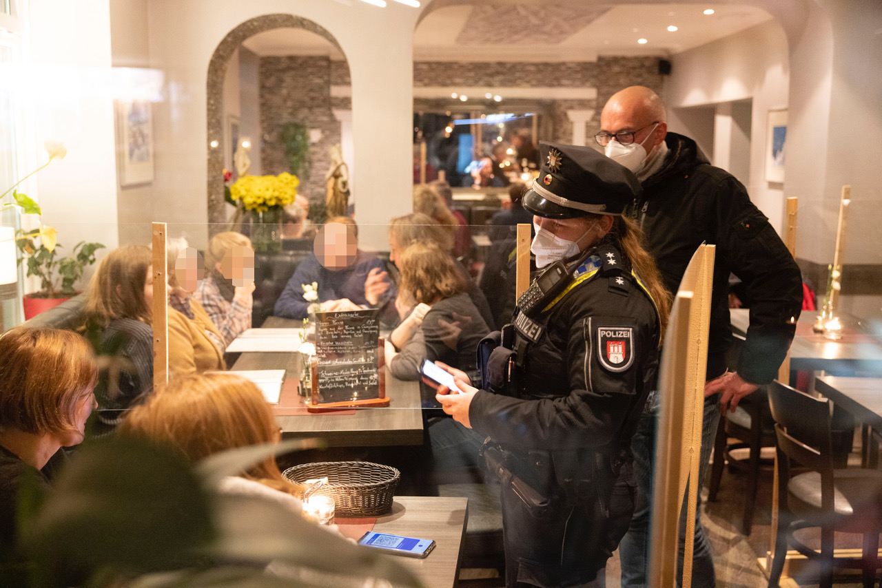 Polizei und Bezirksamt kontrollieren Gäste in einem Restaurant.