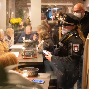 Polizei und Bezirksamt kontrollieren Gäste in einem Restaurant.