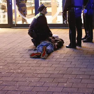 Der Mann wird von Polizisten festgenommen.