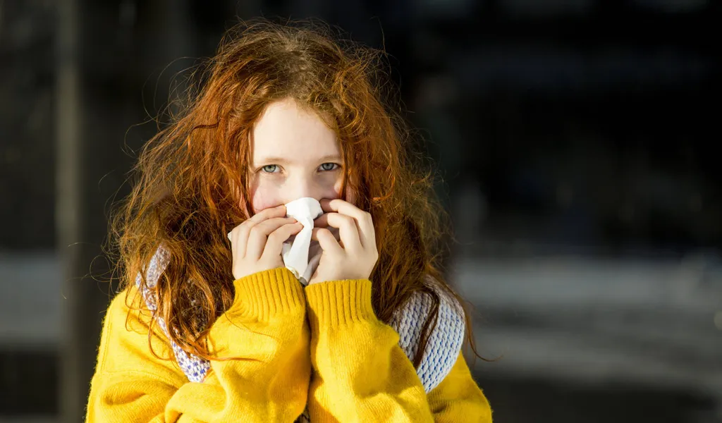 Ein Mädchen putzt sich die Nase. Viele Eltern fragen sich, ob sie ihr Kind mit Erkältungssymptomen in Kitas geben dürfen.