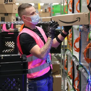 Ein Amazon-Mitarbeiter verstaut Pakete