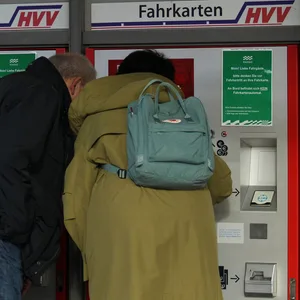Fahrgäste lösen Tickets am Fahrkarten-Automaten des HVV in Hamburg.