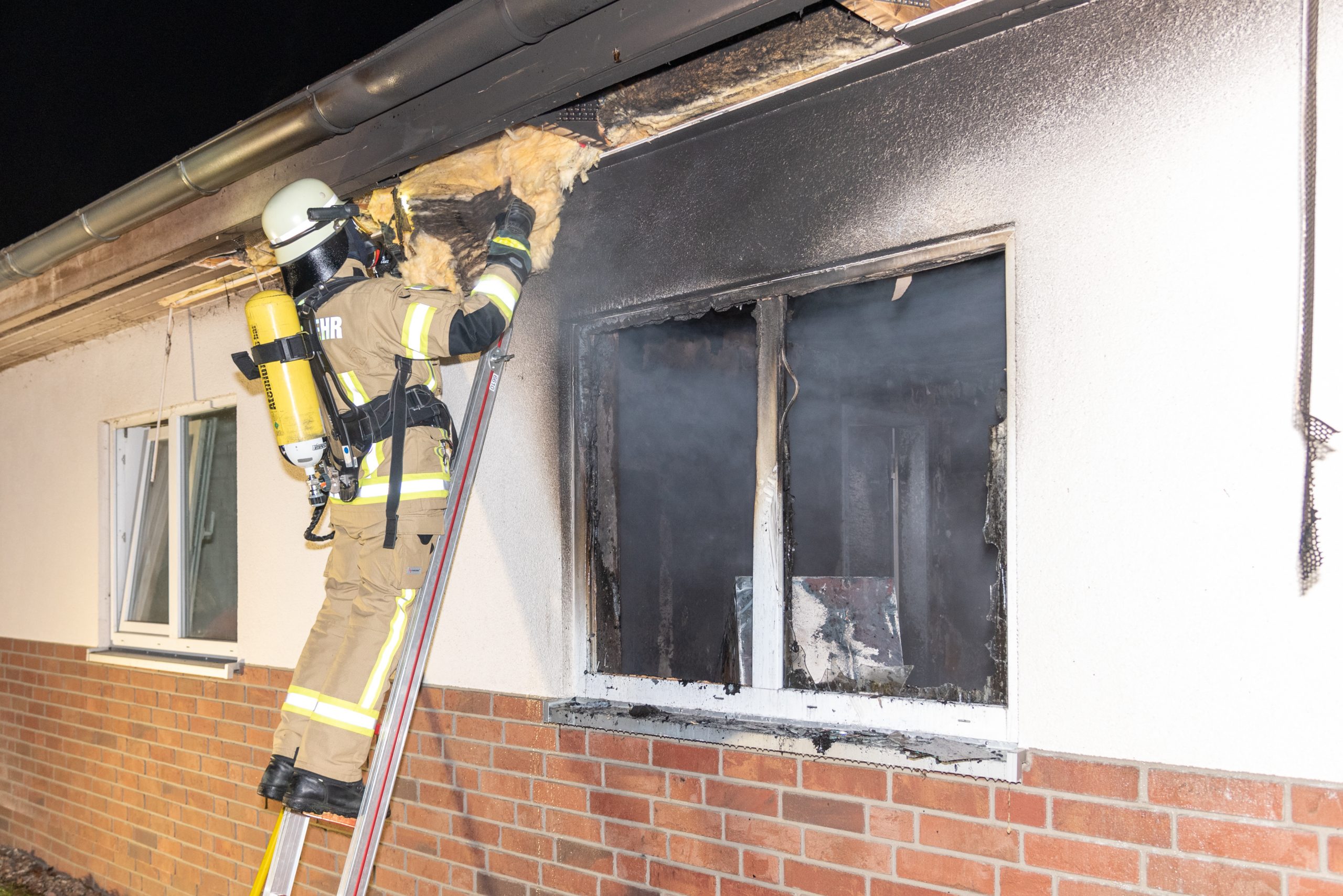 Ein Feuerwehrmann kontrolliert Teile des Dachs nach Glutnestern.