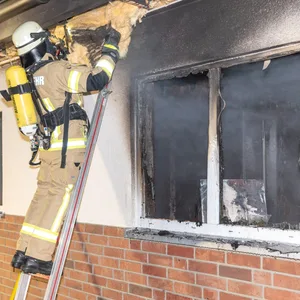 Ein Feuerwehrmann kontrolliert Teile des Dachs nach Glutnestern.