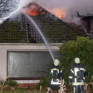 Feuerwehrleute löschen die Flammen im Dachstuhl.