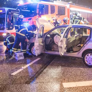 Einsatzkräfte an einem der am Unfall beteiligten Fahrzeuge.