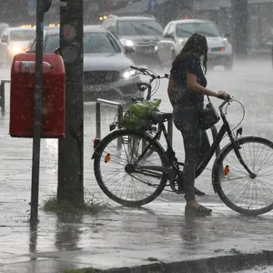 Eine Radfahrerin im Starkregen in Wandsbek im Sommer 2020.