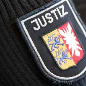 Justizbeamte stehen im Gerichtssaal im Landgericht.
