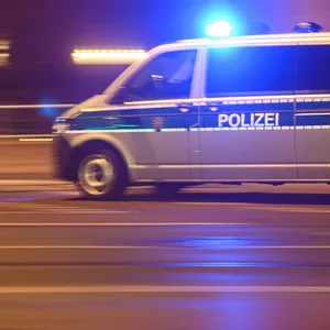 Ein Polizeiwagen mit Blaulicht fährt am Silvesterabend durch die Innenstadt zu einem Einsatz.