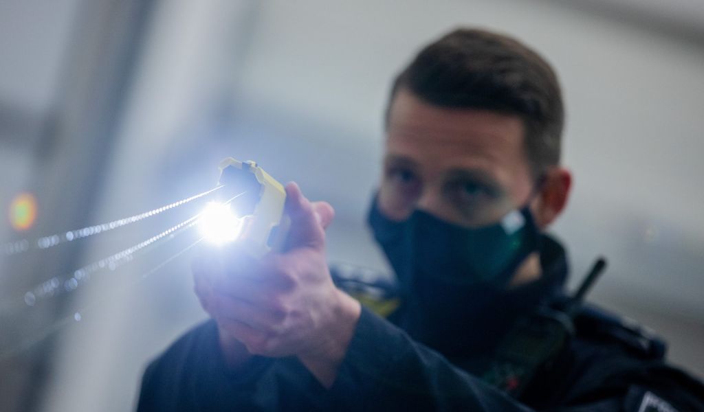 Ein Polizeibeamter aus Nordrhein-Westfalen demonstriert einen Schuss mit einem Taser.