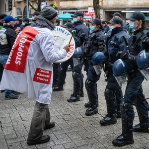 Einsatzkräfte der Polizei versperren Teilnehmern einer Demonstration in der Innenstadt den Weg.