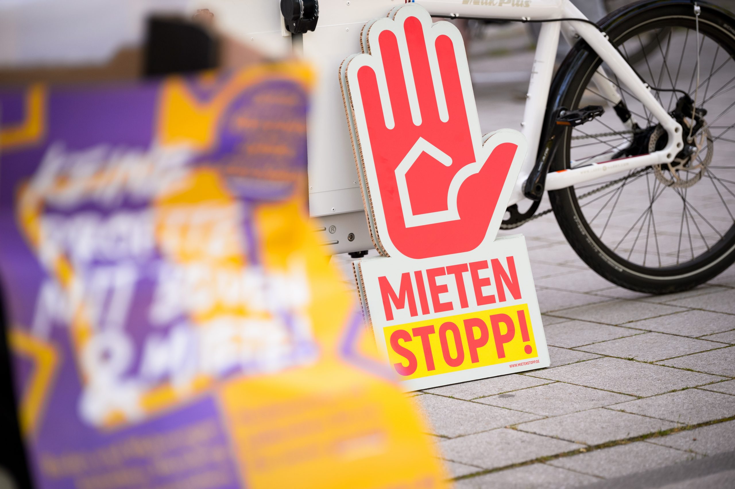 "Mietenstopp" steht auf einem Plakat, das vor dem Start der Demo an einem Fahrrad lehnt.
