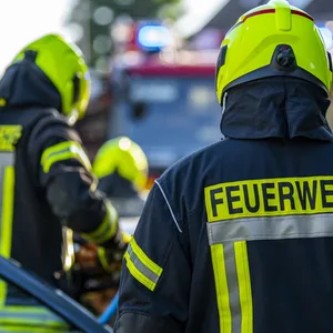 Feuerwehrleute stehen während einer Übung um ein Auto, das einen Unfall gehabt hat.
