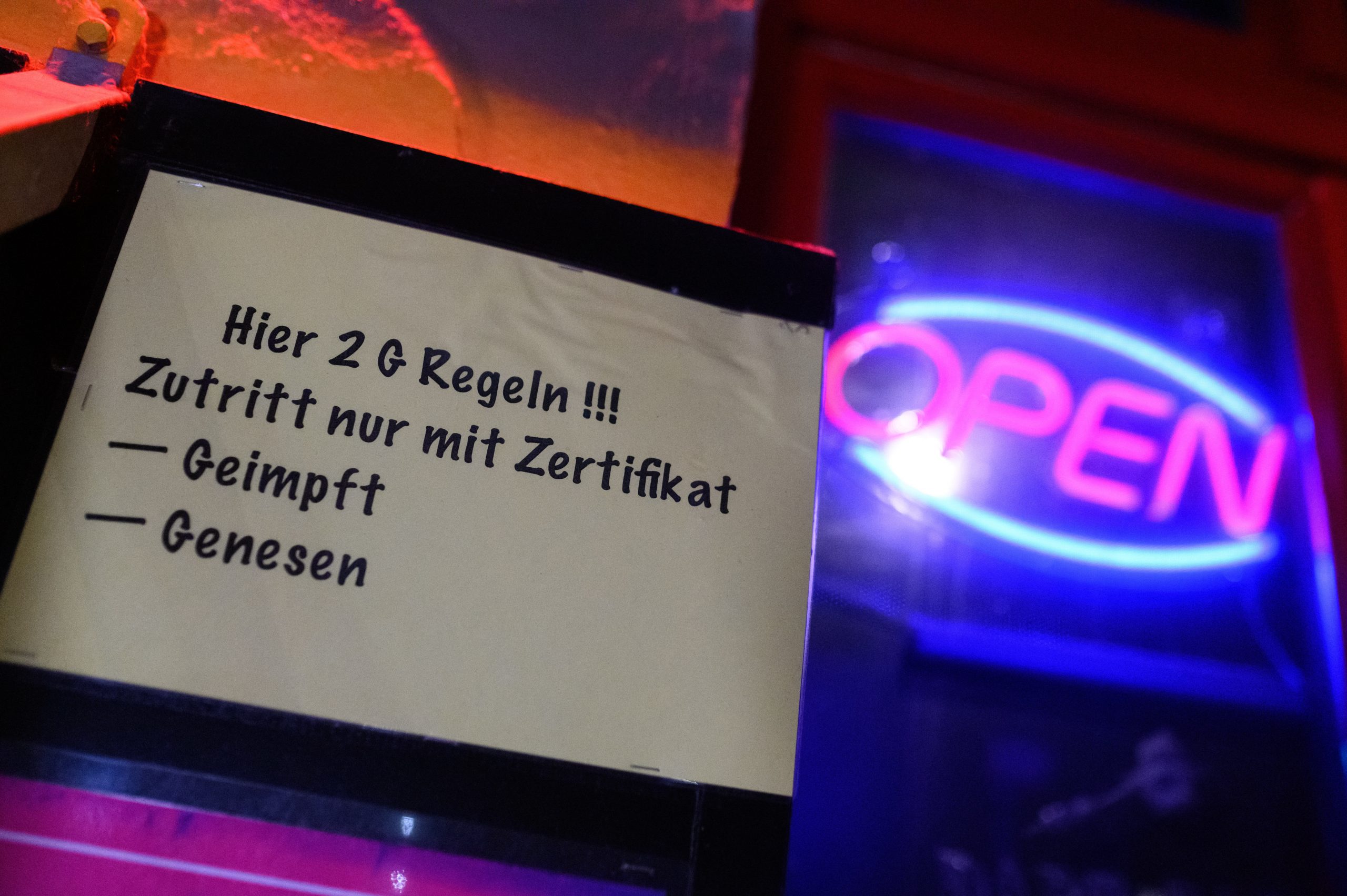 «Hier 2G Regeln !!! Zutritt nur mit Zertifikat - Geimpft - Genesen» steht auf einem Zettel am Eingangs eines Lokals in St. Pauli neben einem «Open»-Leuchtschild.