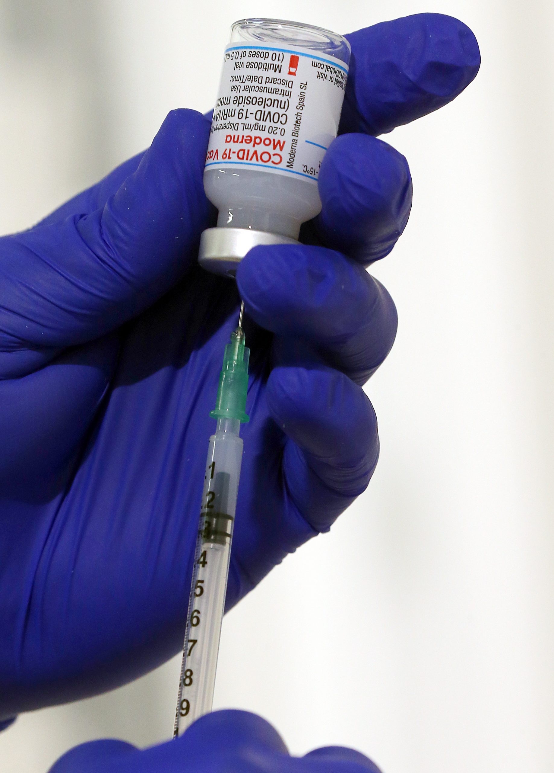 Ein Arzt zieht eine Impfspritze mit dem Serum von Moderna gegen das Coronavirus auf.