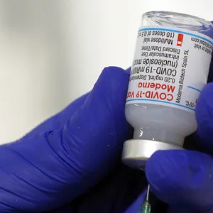 Ein Arzt zieht eine Impfspritze mit dem Serum von Moderna gegen das Coronavirus auf.