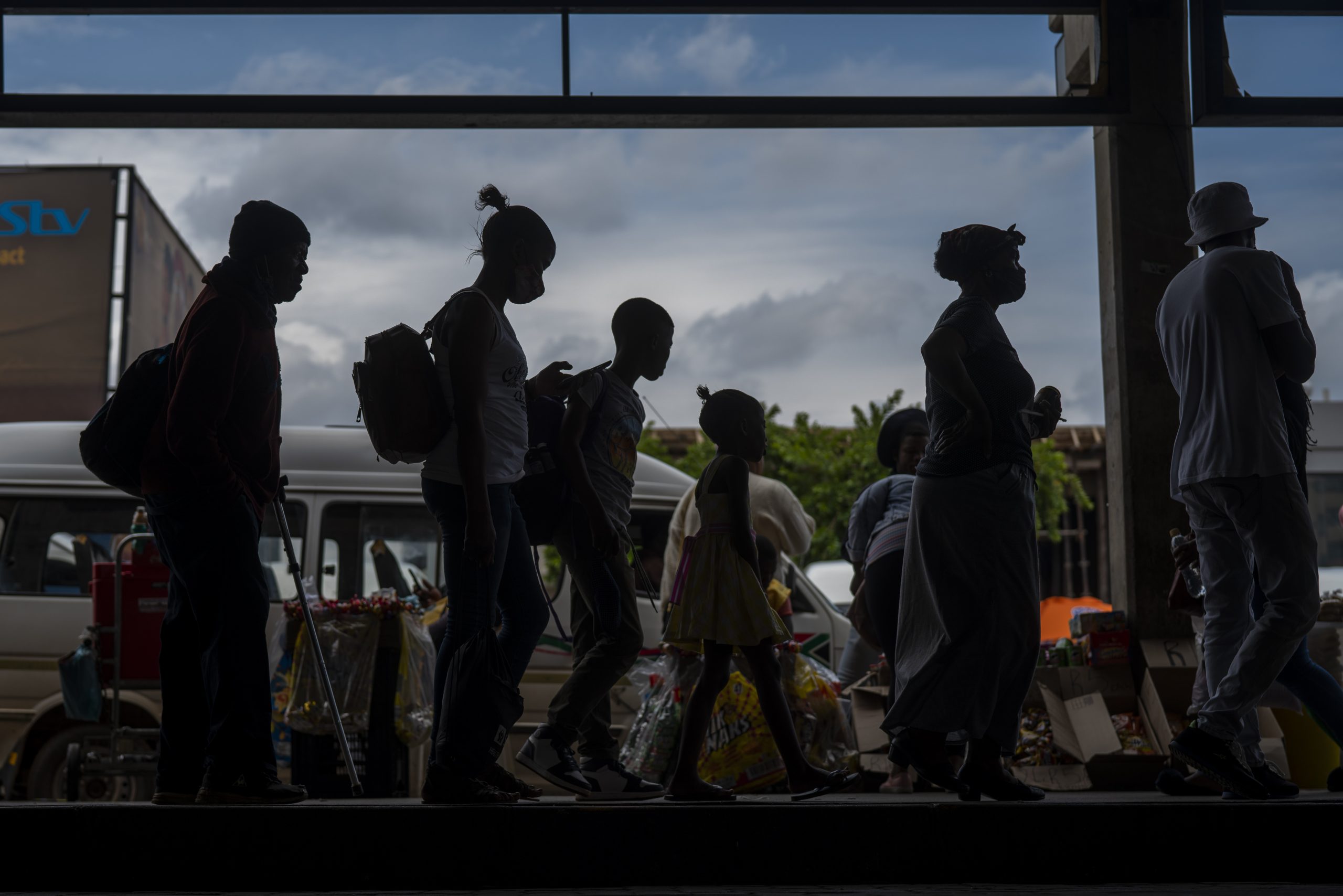 Fahrgäste, von denen einige einen Mund-Nasen-Schutz tragen, warten am Taxistand in Baragwanath, Südafrika.