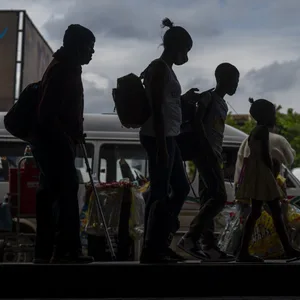 Fahrgäste, von denen einige einen Mund-Nasen-Schutz tragen, warten am Taxistand in Baragwanath, Südafrika.