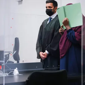 Die Angeklagte und ihr Anwalt Nawied Haschimzada (l) stehen zu Beginn des Prozesses im Gerichtssaal im Strafjustizgebäude.