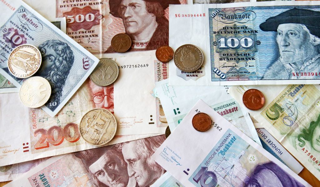 D-Mark-Geldscheine und Münzen liegen auf dem Tisch.