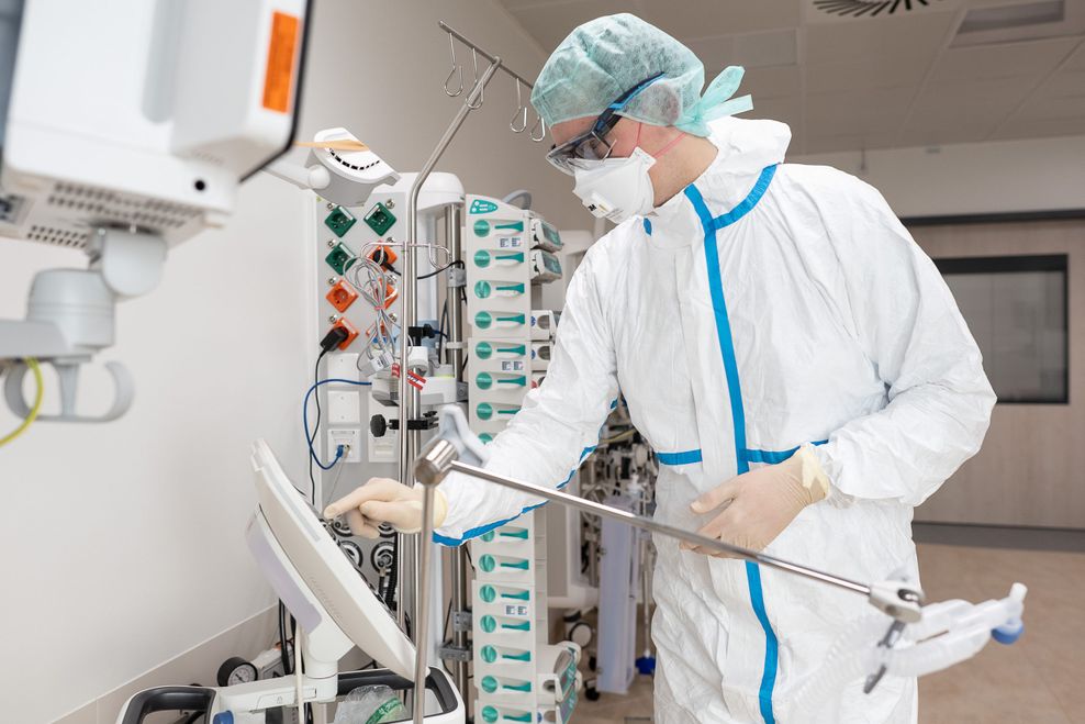 Lenard Bornemann, Gesundheits- und Krankenpfleger an der Universitätsmedizin Göttingen (UMG), bedient in einem Patientenzimmer des Intensivmodul-Gebäudes ein Beatmungsgerät.