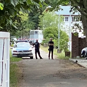 Polizisten sperren den Tatort auf dem Reiterhof ab.