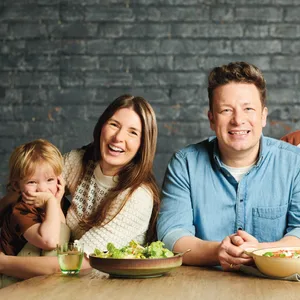 Jamie Oliver lächelt zwischen seiner Frau und drei seiner Kinder