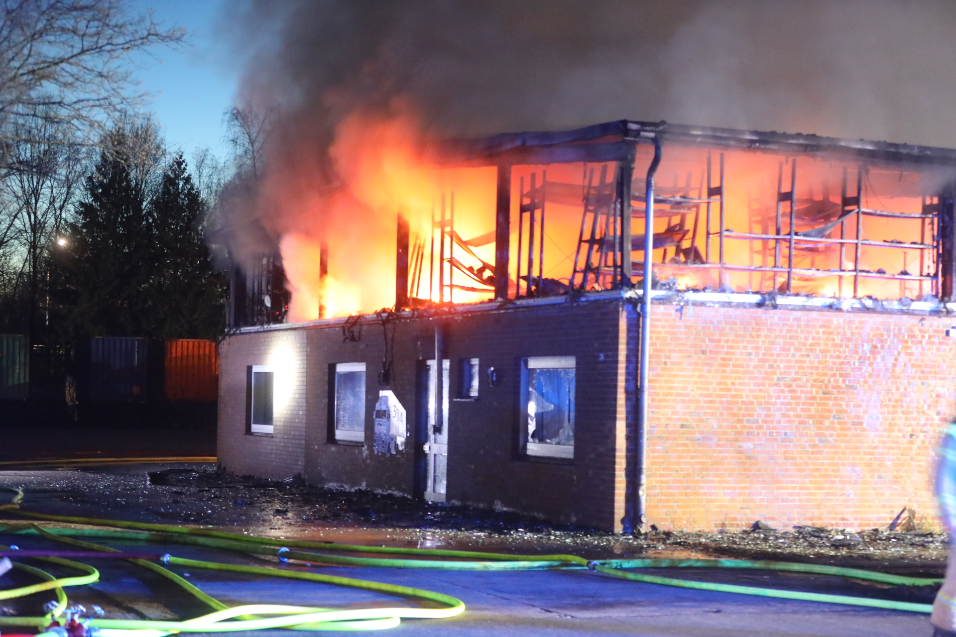 Flammen treten aus einem Gebäude, das obere Stockwerk ist zerstört