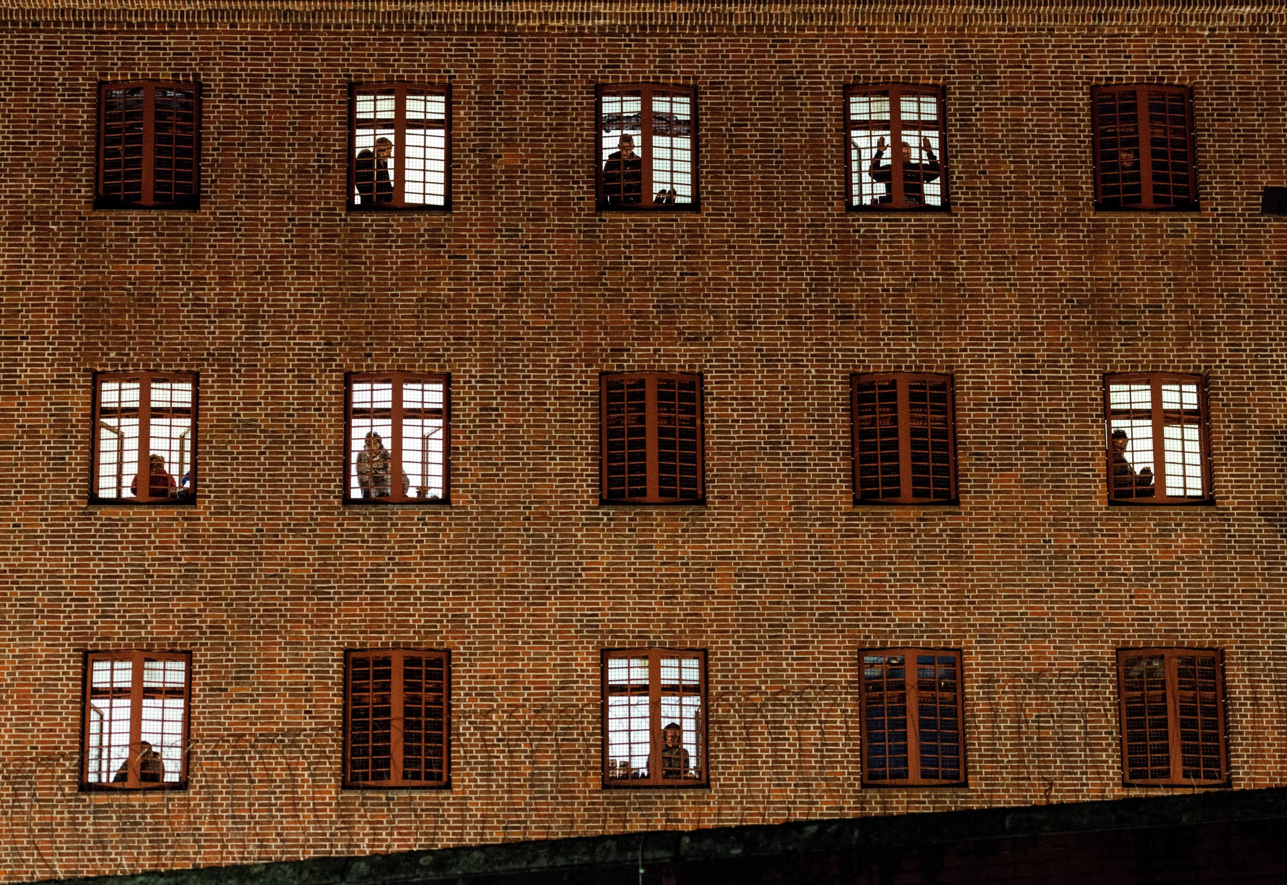 Insassen der Untersuchungshaftanstalt Hamburg schauen aus ihren Zellenfenstern.