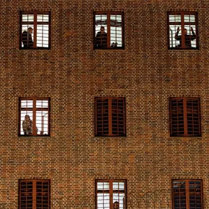 Insassen der Untersuchungshaftanstalt Hamburg schauen aus ihren Zellenfenstern.