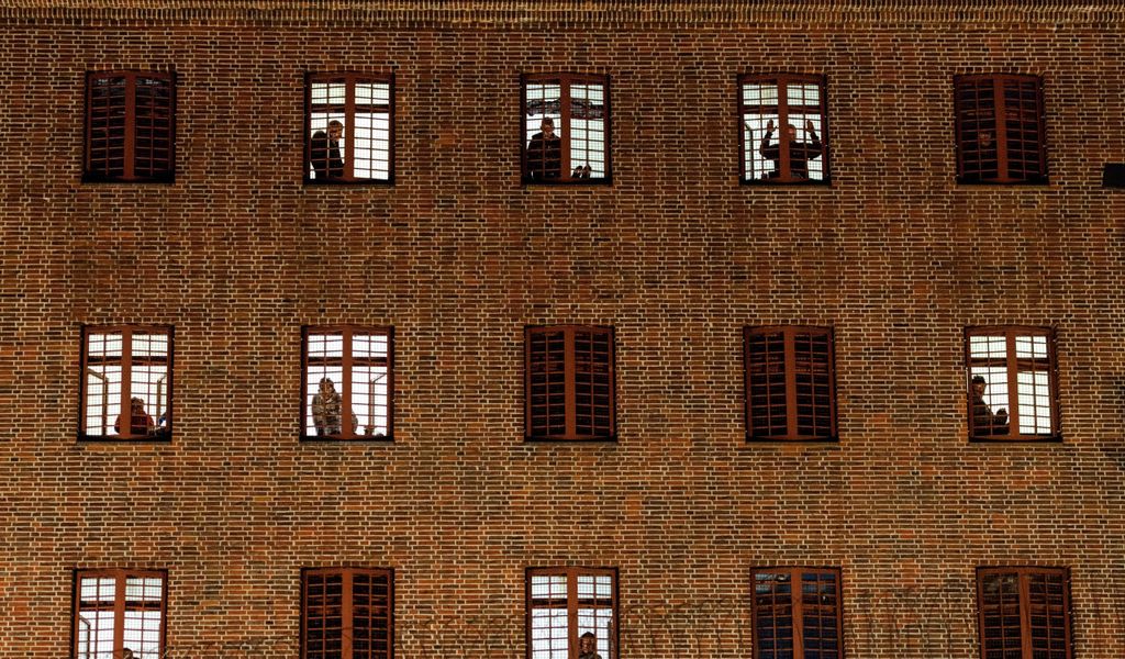 Insassen der Untersuchungshaftanstalt Hamburg schauen aus ihren Zellenfenstern.